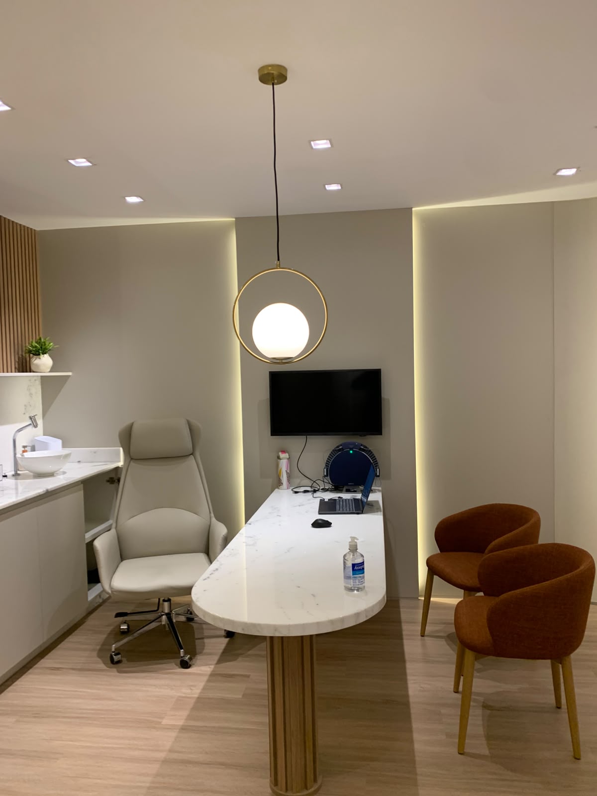 Sala comercial com pendente, spots e sanca de LED acesa